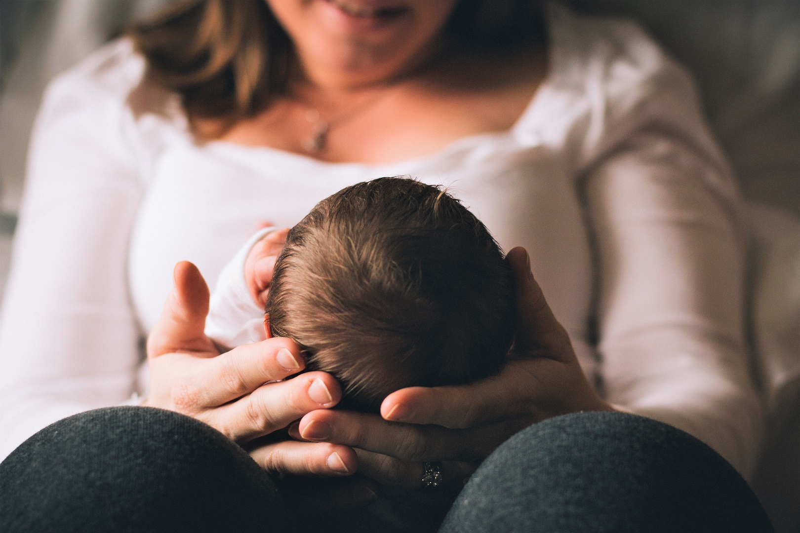 Sitting Mother Holding Newborn Baby Head Hair