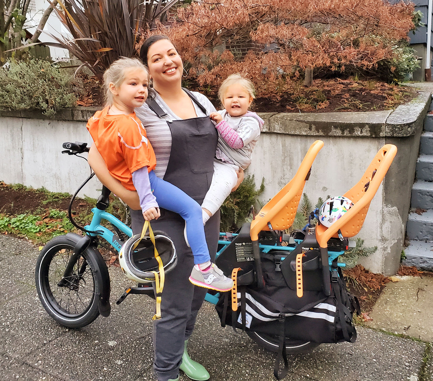 mother holding kids near family bike