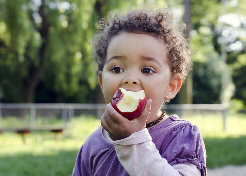 little girl eating an apple