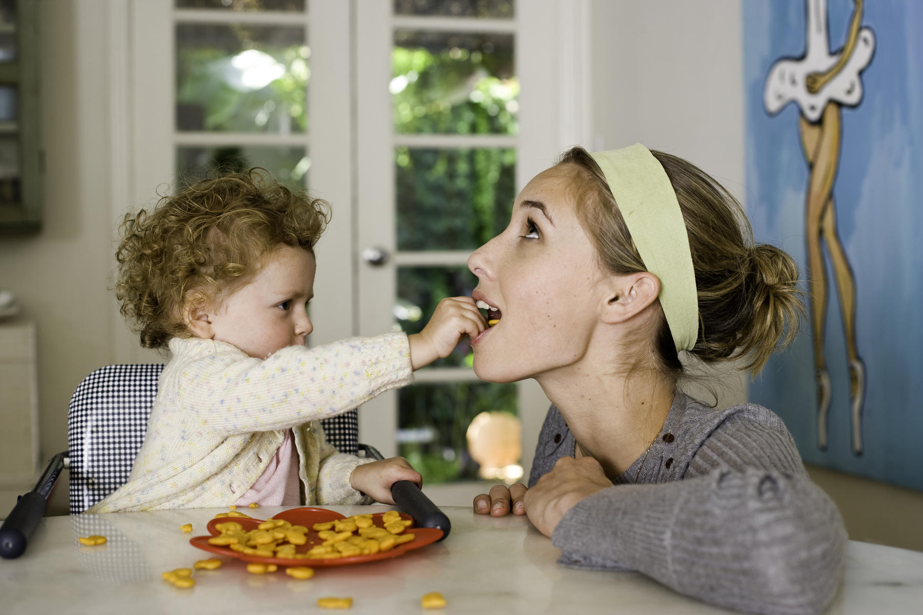 Toddler in high chair feeding mom