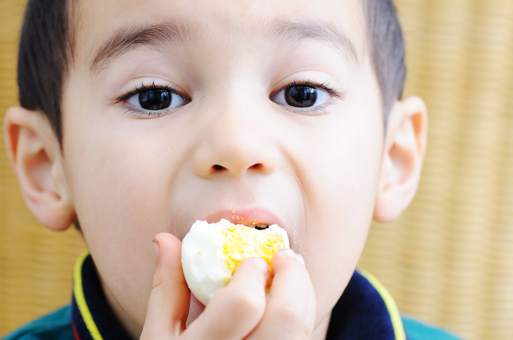 Boy eating an egg