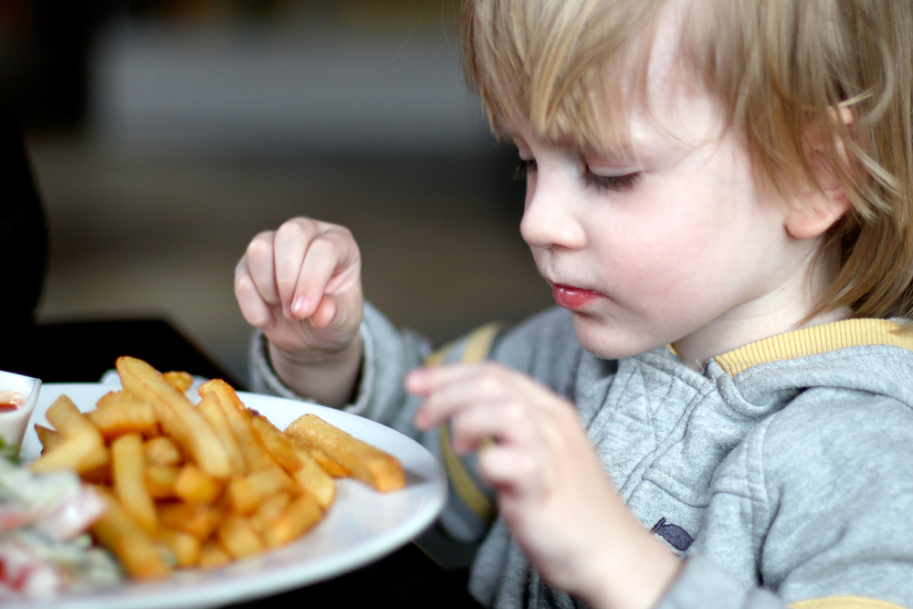 Young boy eating french fries