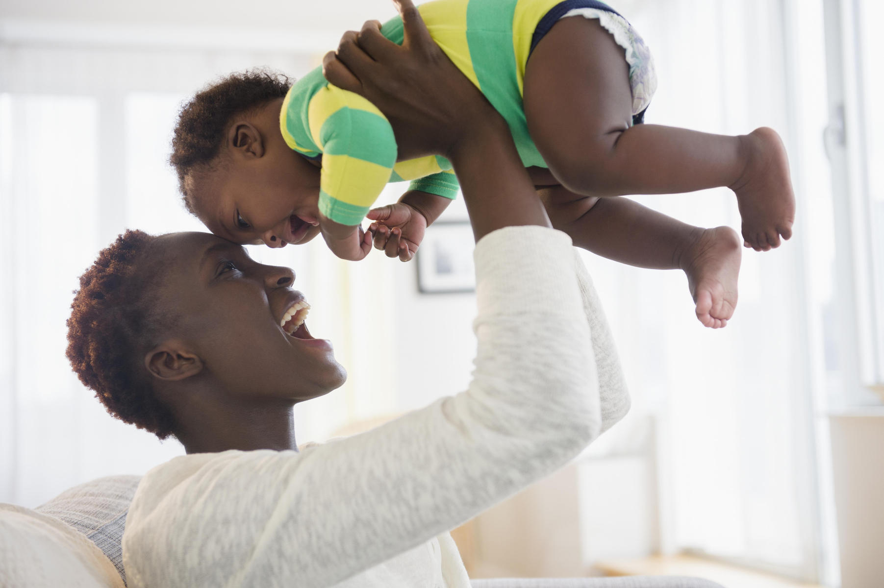 happy mom lifting baby