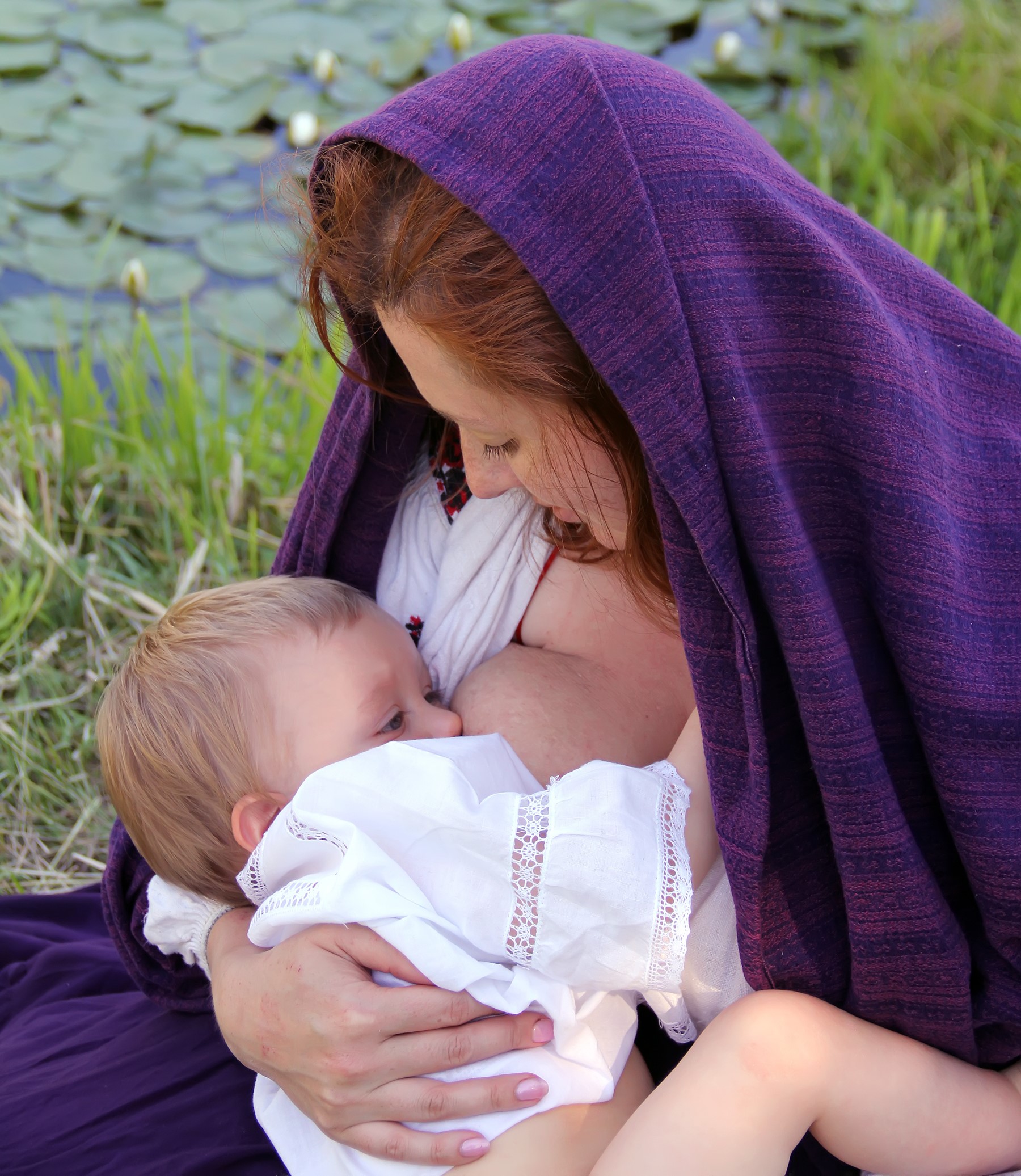 Mother Breastfeeding Child Outside Wearing Shawl On Head